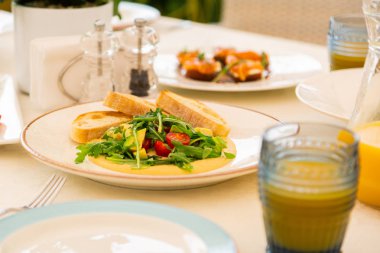 Bruschetta arugula ve avokado salatası yakınında plaka üzerinde yalan