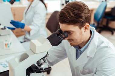 Profesyonel bir mikroskop kullanarak Nice yakışıklı biyolog