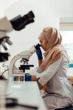 Biyo laboratuvarda test örneklerini inceleyen ciddi düşünceli kadın