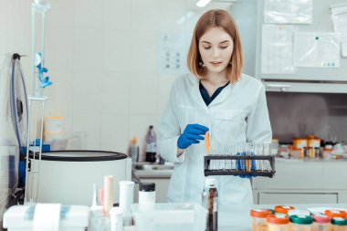 Akıllı genç kadın muayene için test tüpleri alıyor