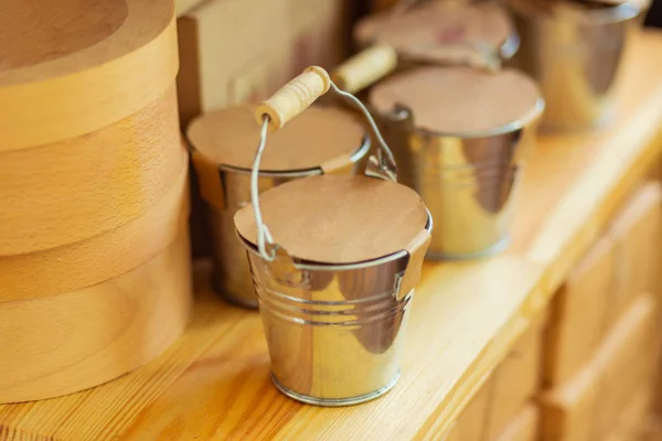 Decorative metal buckets standing on a shop shelf. — Stock Photo, Image