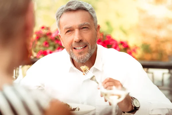 Guapo barbudo hombre maduro comiendo y hablando con su esposa — Foto de Stock