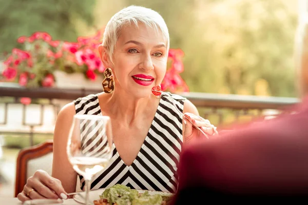 Reife Frau mit leuchtend rosa Lippen isst Salat und spricht mit Ehemann — Stockfoto