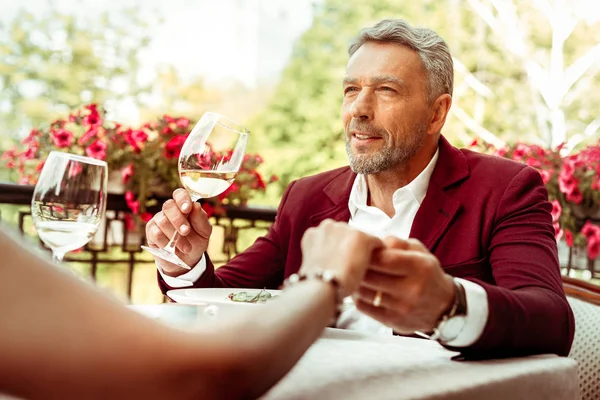 Bearded grey-haired businessman having romantic dinner with wife