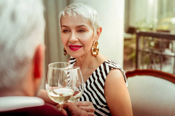 Szép idős hölgy iszik fehérbort férjével munka után — Stock Fotó