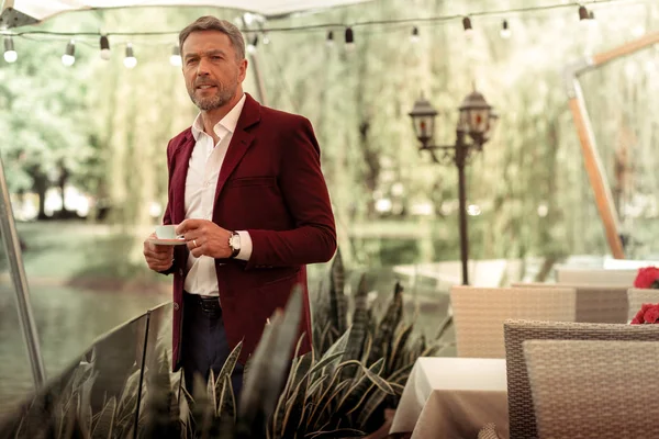 Bearded mature man wearing stylish jacket drinking coffee outside — Stock Photo, Image