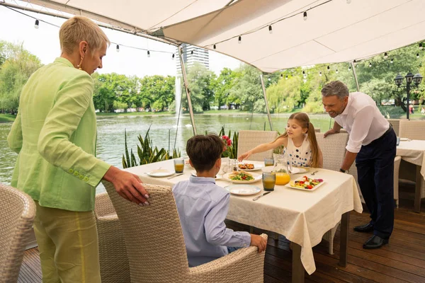 Prarodiče, kteří přicházejí na vnoučata s snídaní venku — Stock fotografie