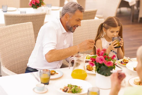 Unokája iszik narancslé mellett ül nagypapa — Stock Fotó