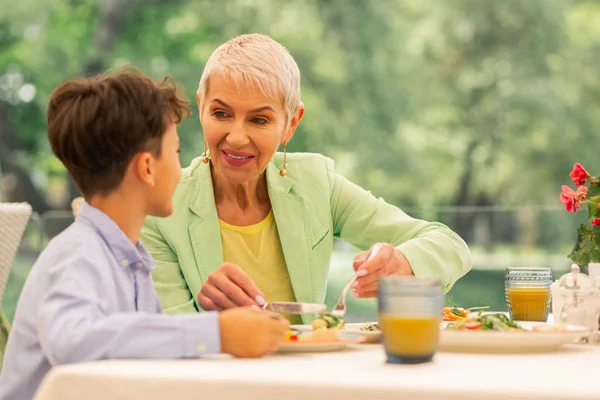 Oma schaut Enkel beim Frühstück an — Stockfoto