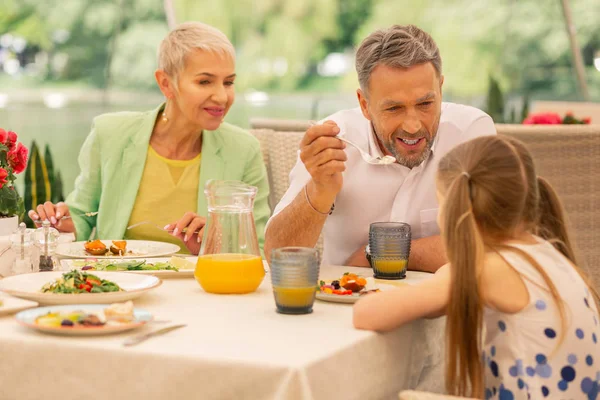 Nonni parlando con la loro bella ragazza e facendo colazione — Foto Stock