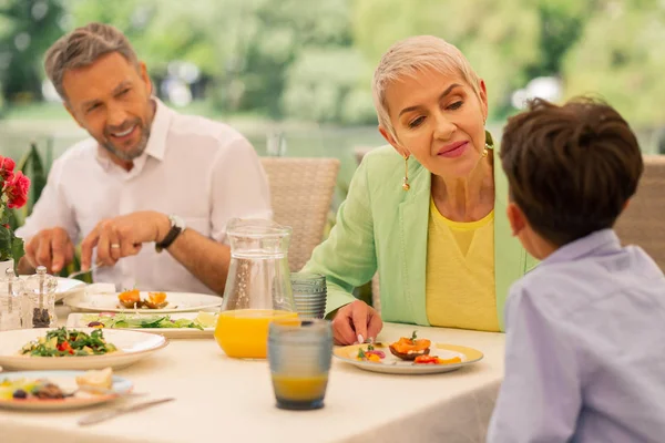 Großmutter kümmert sich beim Frühstück um ihren Enkel — Stockfoto