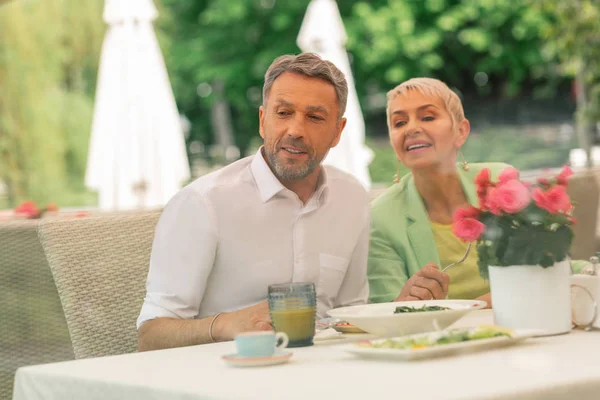 Cinzento de cabelos bonitos marido tomando café da manhã com bela esposa — Fotografia de Stock