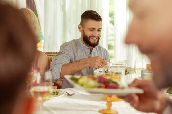 Schöner dunkelhaariger Mann beim Mittagessen mit seinen Eltern — Stockfoto