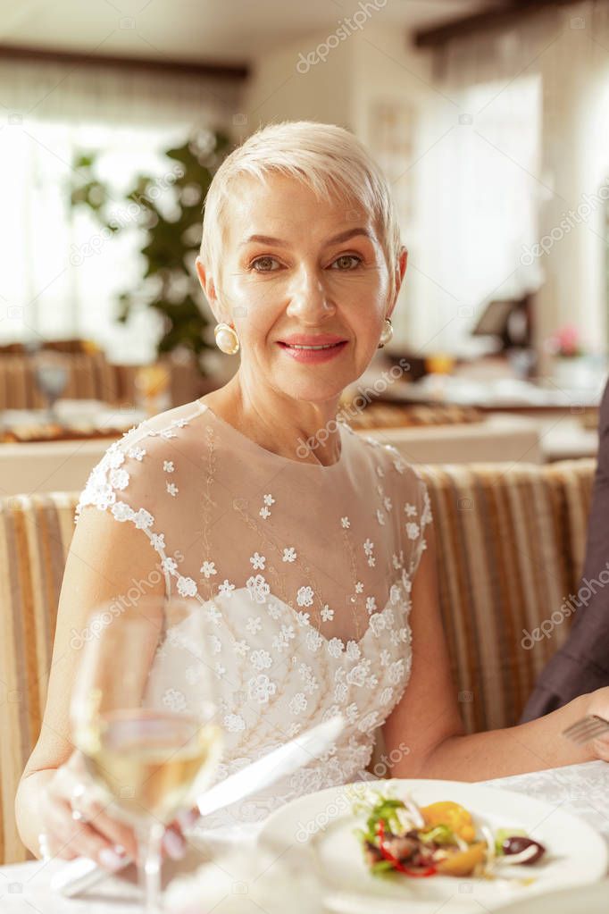 Beautiful aged bride holding glass of champagne