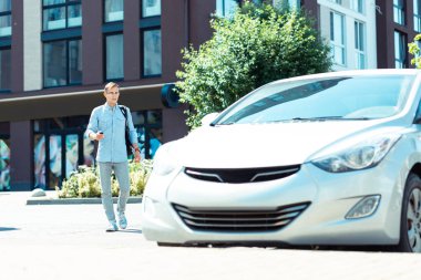 Başarılı işadamı sabah arabasına yürüyor