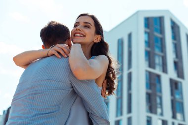 Ağılçıplak koyu saçlı karısı, şefkatli kocasına sarılıyor