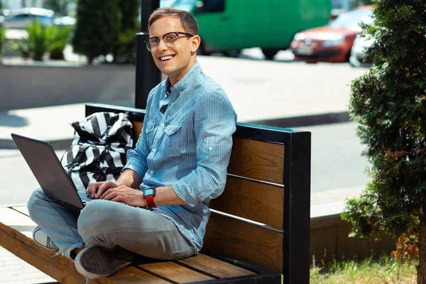 Freelancer enjoying work on laptop while sitting in residential area