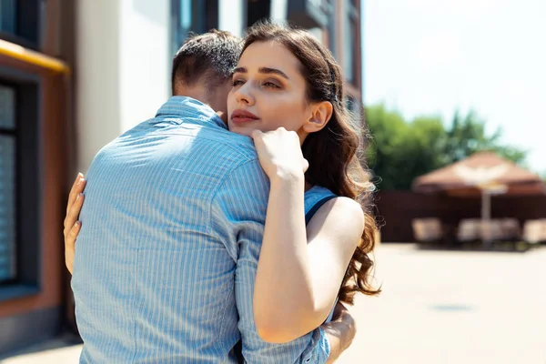 Όμορφη σγουρά μελαχρινή γυναίκα αγκαλιάζει τον υποστηρικτικό άντρα της — Φωτογραφία Αρχείου