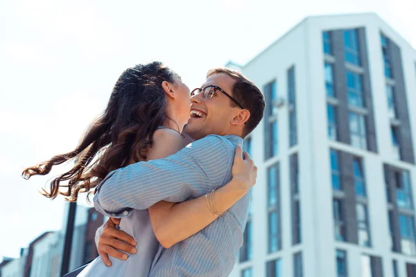 Loving supportive husband lifting his curly young wife — Stock Photo, Image