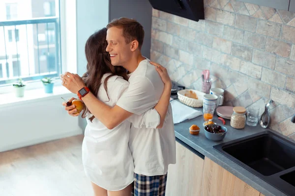 Kochający mąż ubrany w inteligentny zegarek przytulanie jego śliczną kobietę — Zdjęcie stockowe