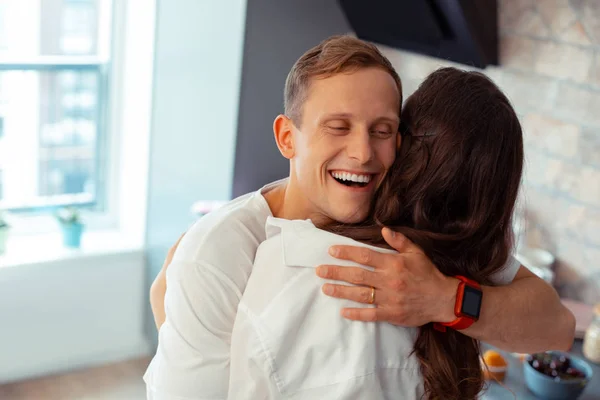 Bonito marido feliz vestindo inteligente relógio abraçando esposa — Fotografia de Stock