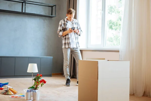 Marido de pé na sala enquanto se move para novo apartamento — Fotografia de Stock