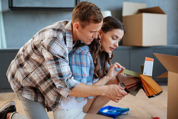 Couple choosing the color of fabric for their furniture in new house — Stock Photo, Image