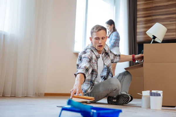 Man uitpakken van de doos terwijl verhuizen naar nieuw huis — Stockfoto