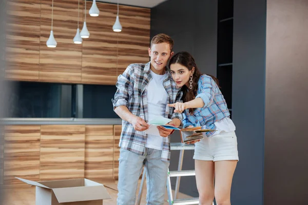Couple looking at color palettes before painting walls in new house — Stock Photo, Image