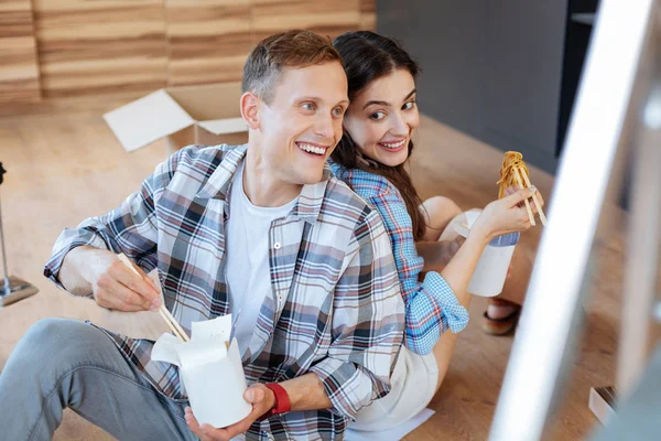Casal comer macarrão depois de desempacotar caixas com coisas — Fotografia de Stock