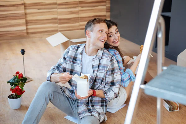 Marido e mulher comendo macarrão gostoso sentado no chão — Fotografia de Stock