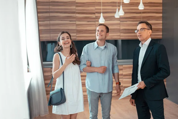 Elegante joven esposa sonriendo eligiendo casa con marido — Foto de Stock