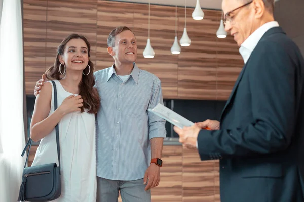 Couple looking at realtor preparing documents for buying house — Stock Photo, Image