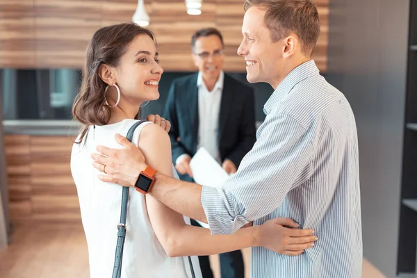 Husband wearing smart watch hugging wife while buying the house — Stock Photo, Image
