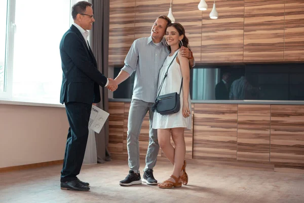Realtor estrechando la mano de los clientes comprando la casa — Foto de Stock