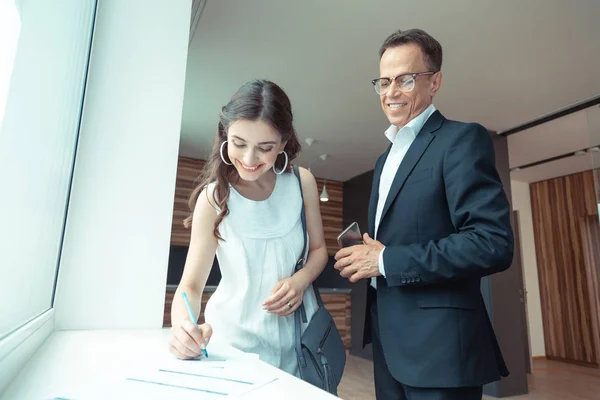 Realtor assistindo o cliente assinar os papéis depois de comprar casa — Fotografia de Stock