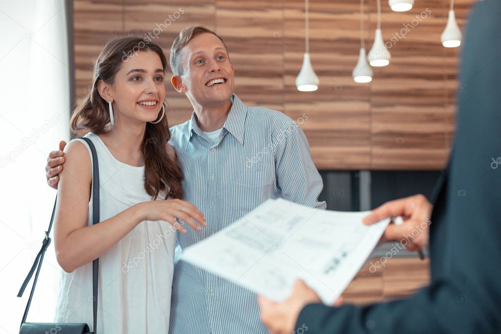 Couple looking at realtor giving them the documents