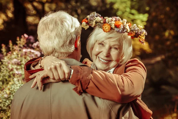 Веселая пожилая женщина обнимает своего мужа в парке . — стоковое фото