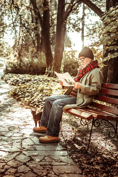 Elderly man reading his newspaper in the park. — Stock Photo, Image