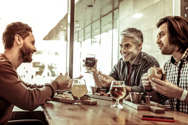 Радісні чоловіки проводять час разом у кафе — стокове фото