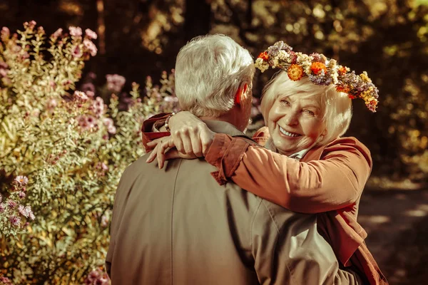 Two happy seniors hugging during outdoor date.