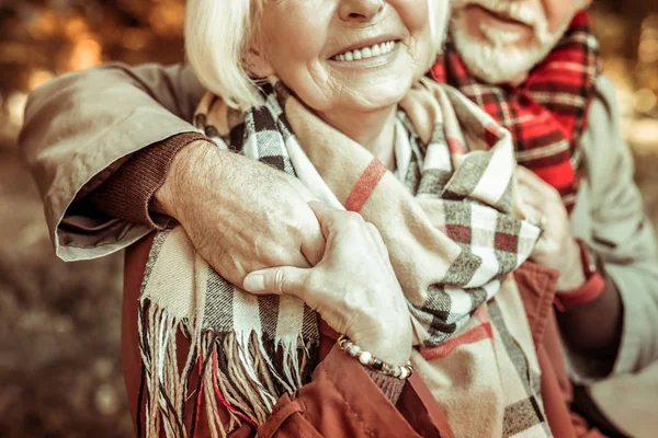 Пожилые супруги обнимаются и держатся за руки . — стоковое фото