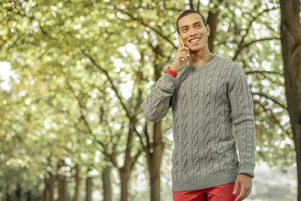 Rayonnement brun gars en pantalon rouge ayant un appel téléphonique — Photo