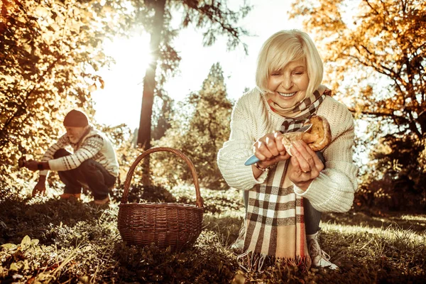 Lachende vrouw snijden een Stipe van een paddestoel. — Stockfoto