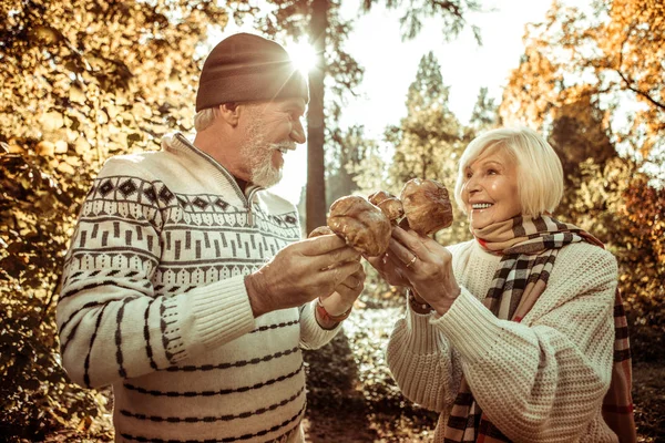 Mann und Frau halten Pilze in der Hand und schauen einander an. — Stockfoto