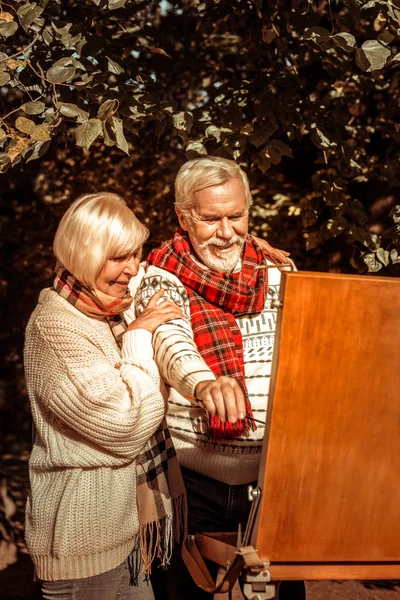 Žena povzbuzující manžela, aby maloval krajinu. — Stock fotografie