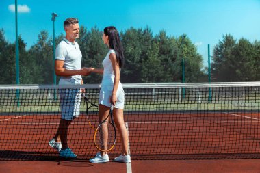 Yakışıklı koca karısının elini sıkarken gülümsüyor