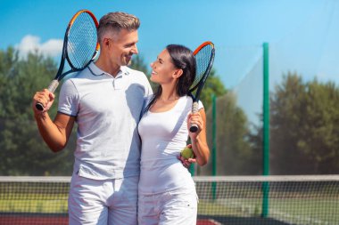 Tenisi çok seven çift raketleri tutuyor