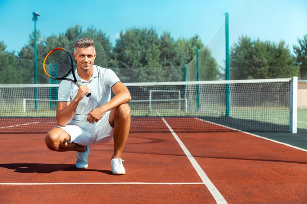 Pohledný šedovlasý obchodník s tenisovým rámusu — Stock fotografie