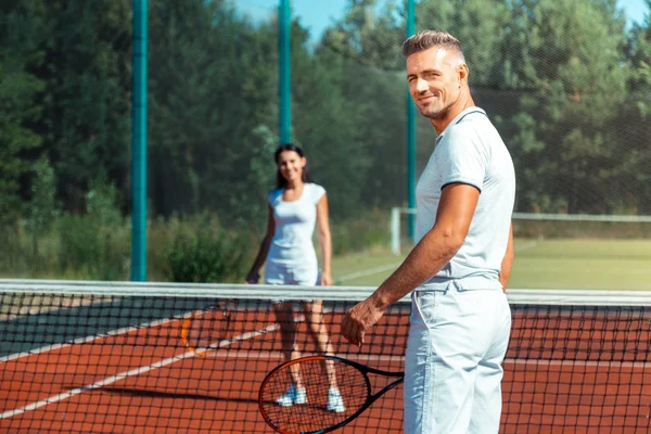 Beaming marido sentirse increíble jugar al tenis con la esposa —  Fotos de Stock